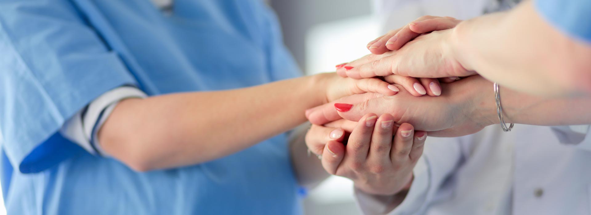 Doctors and nurses in a medical team stacking hands