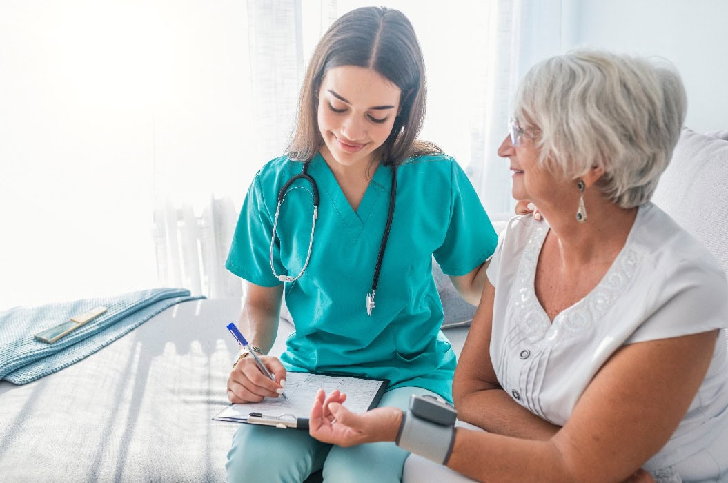 Krankenschwester misst den Blutdruck einer älteren Frau zu Hause. 